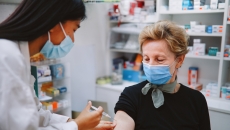 
  Pharmacist giving a person an injection 
