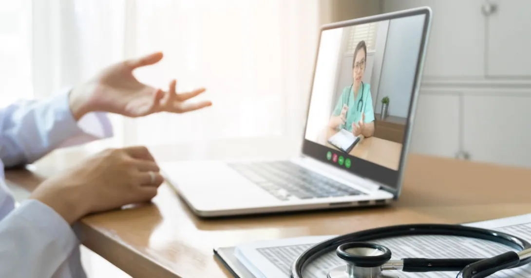 
  Person sitting at a desk while talking to a healthcare professional on the computer
